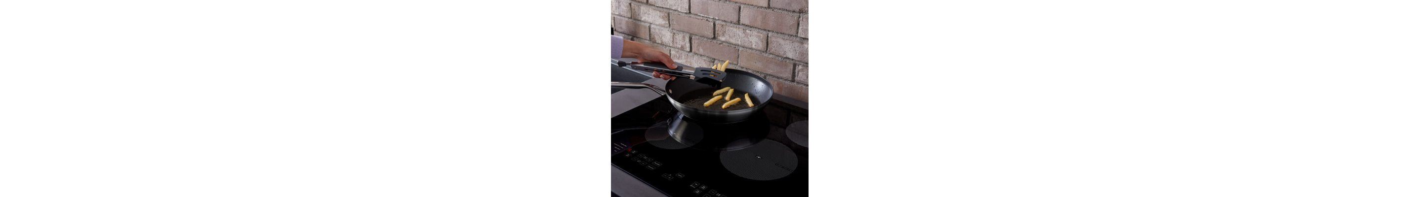 Person frying french fries in a skillet on an electric stovetop