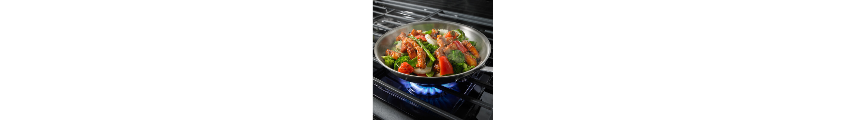 Vegetable stir fry in a skillet on a gas stove top burner
