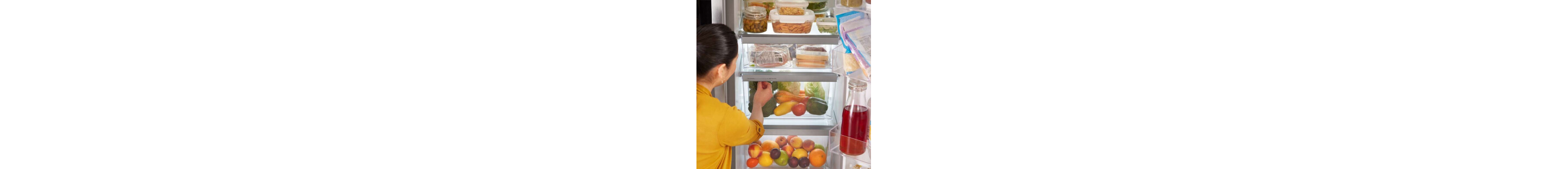 Person reaching inside a stocked refrigerator
