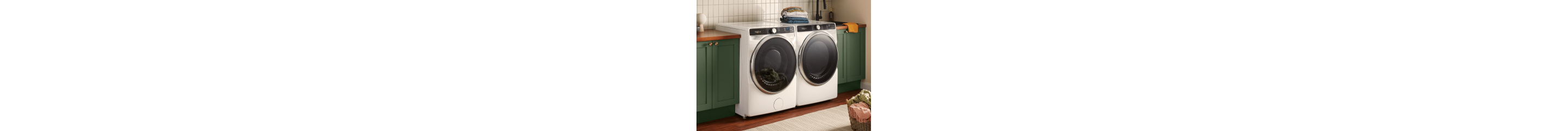 White front load washer and dryer set next to green cabinets