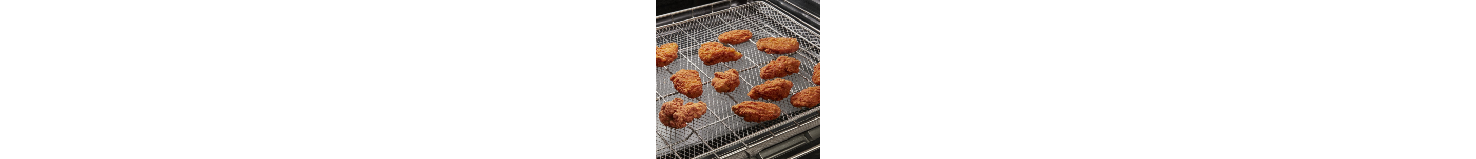 Chicken wings air frying on a tray