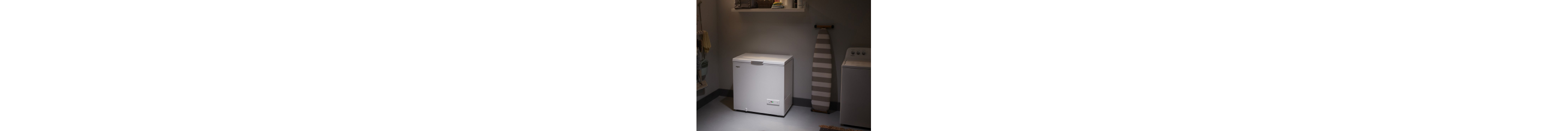 A white chest freezer in a garage