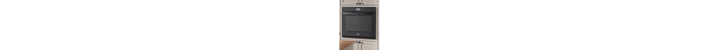 Black wall oven built into white cabinets