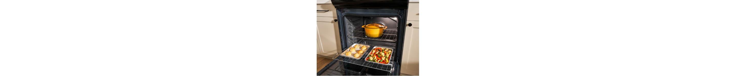 An open oven door exposing two pans with food in them and a closed Dutch oven