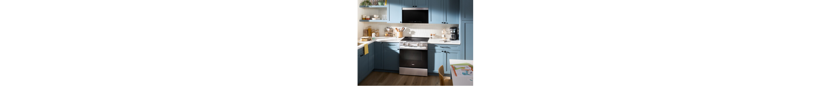 A kitchen with blue cabinetry and an induction cooktop with an over-the-range microwave above it