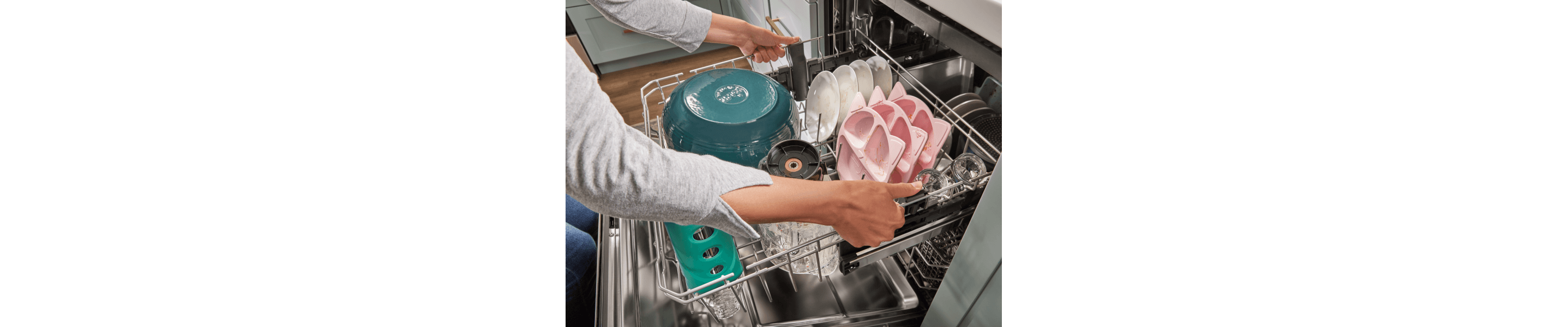 Person adjusting the top rack of a Whirlpool® dishwasher