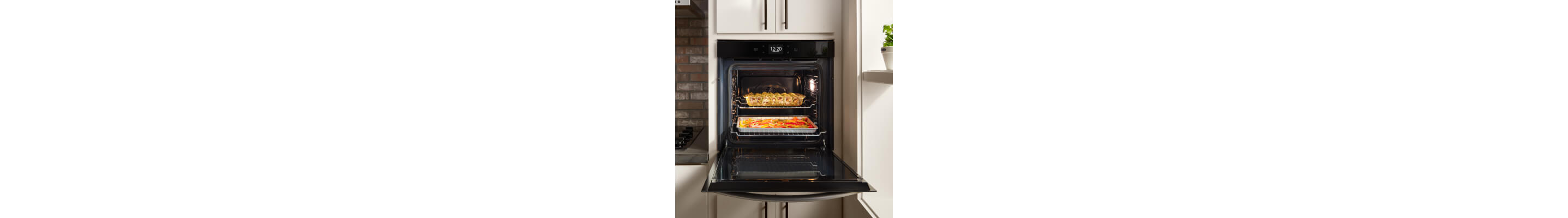 Black Whirlpool® single wall oven with food inside set into white cabinets. 