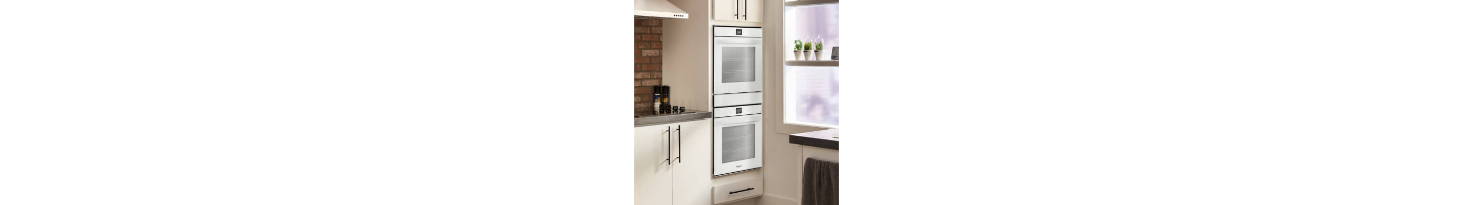 Whirlpool® stainless steel double wall oven set into white cabinets