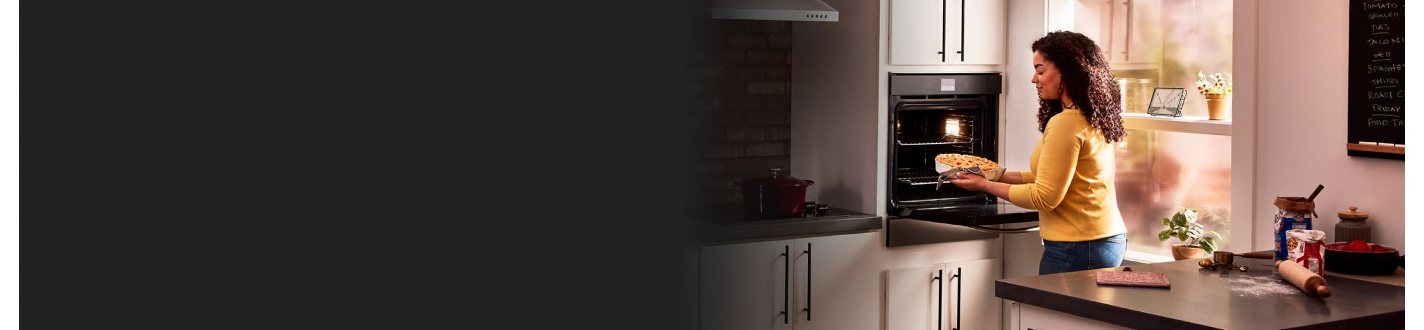 Women placing pie into Whirlpool® wall oven