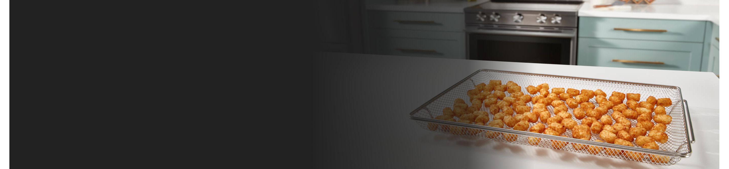 Tater tots in an air fry basket on a kitchen island