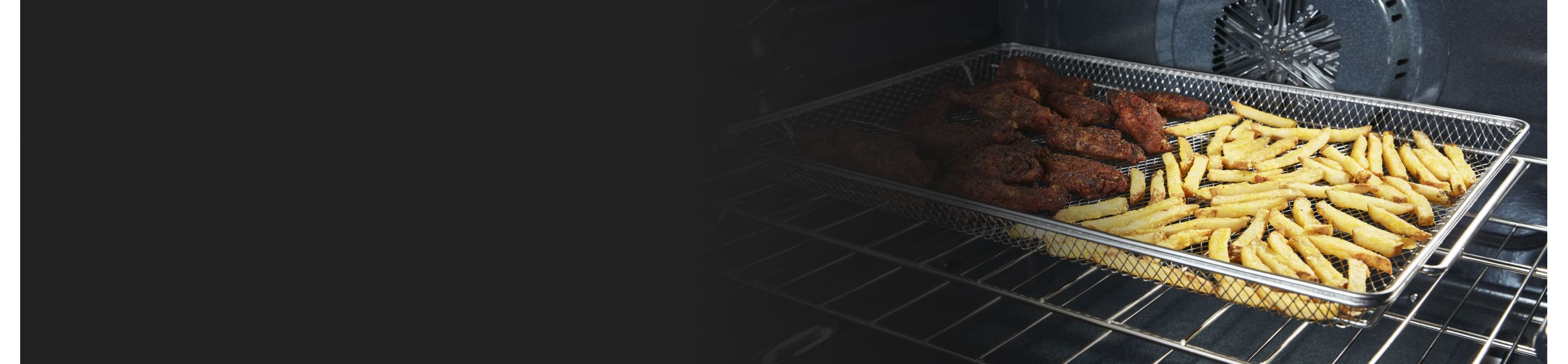 Inside oven with food cooking in an air fry basket.