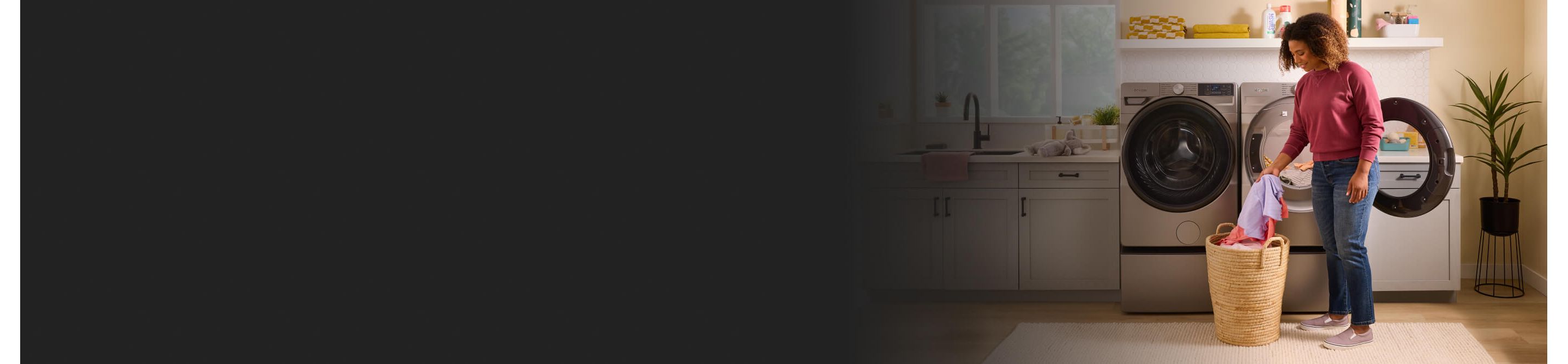 Person loading laundry into a front load washer and dryer set