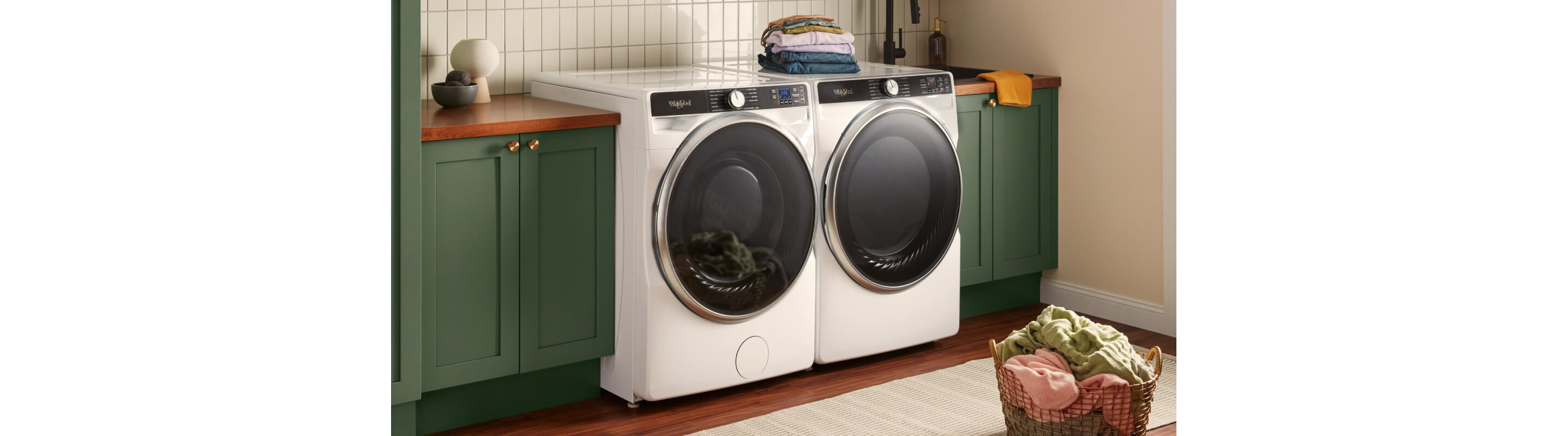 White Whirlpool® Front Load Washer and Dryer next to green cabinets