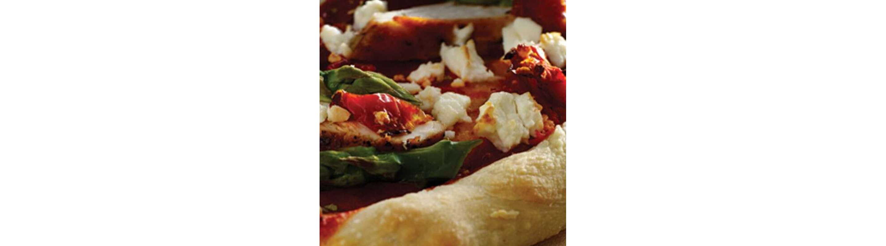 Close-up of pizza with cheese crumbles and greens on top