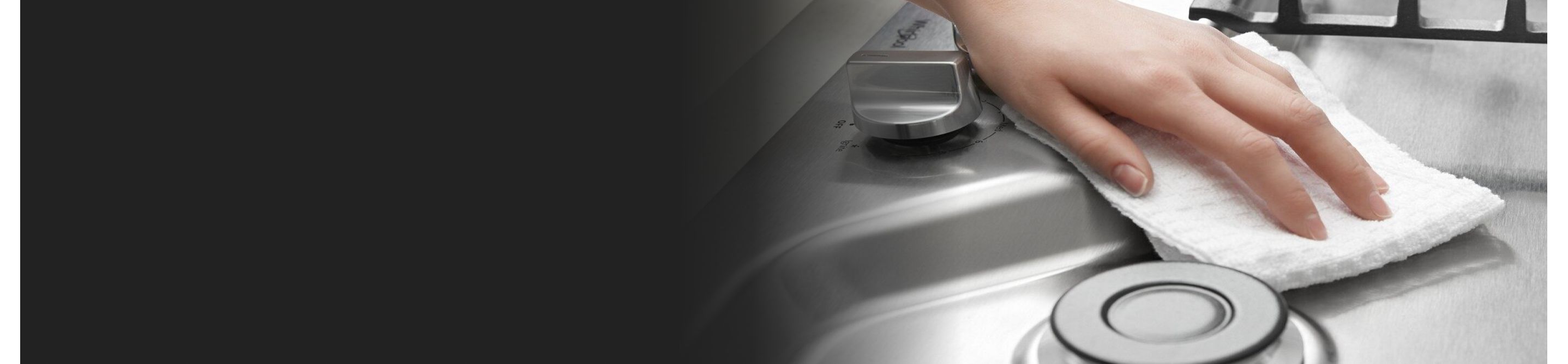 Person cleaning stainless steel cooktop