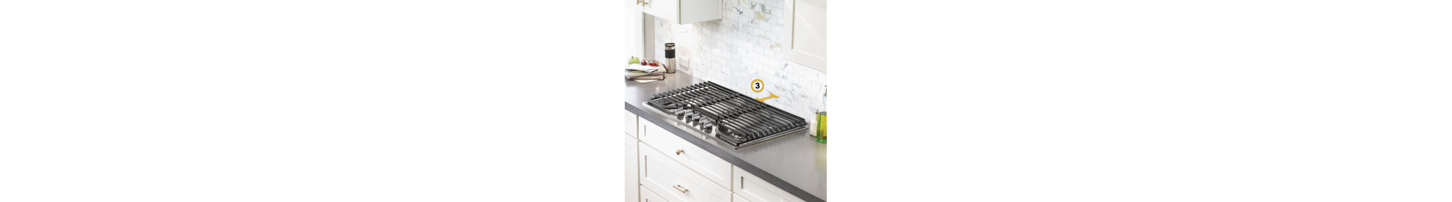 Gas cooktop set into gray countertop with measurements noted for distance between cooktop and wall