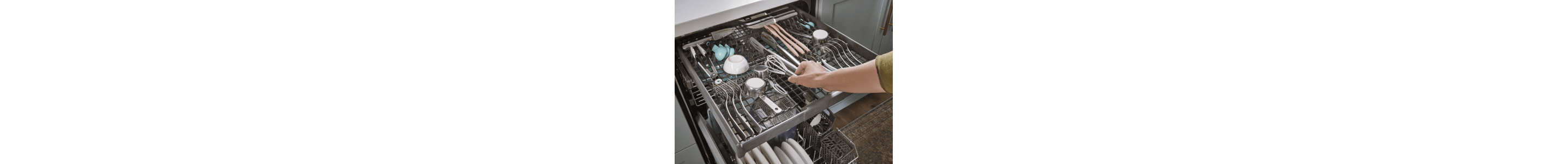 Person placing items on the 3rd rack of a dishwasher