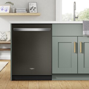 A dishwasher located at the end of grey cabinets