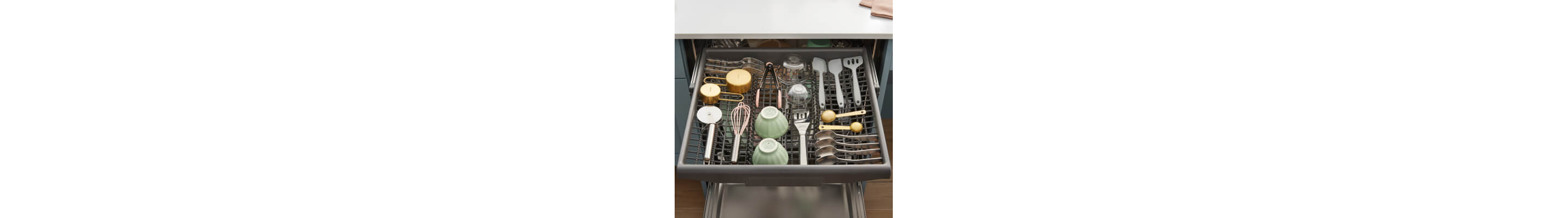 Miscellaneous utensils loaded in a dishwasher’s third rack