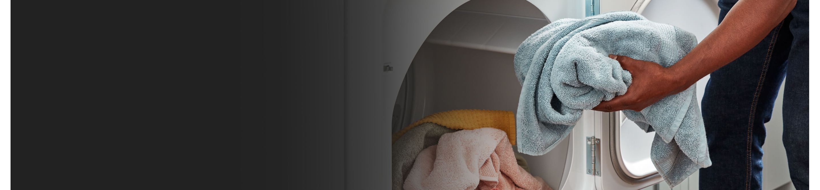 Person loading towel in dryer