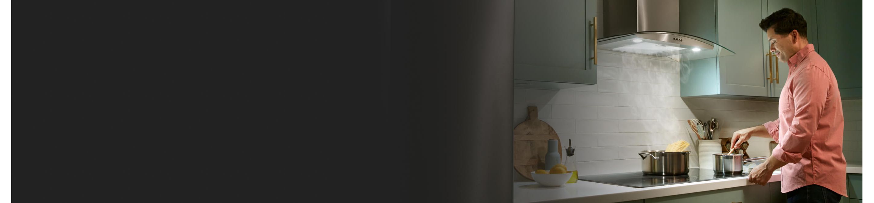Person cooking on a cooktop with a wall mount range hood above