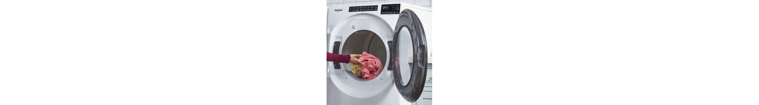 Hand putting items of clothing into a front load dryer