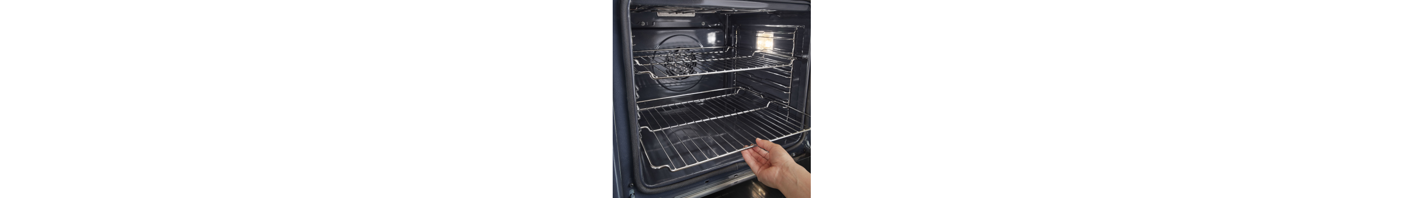 A hand inserting an oven rack