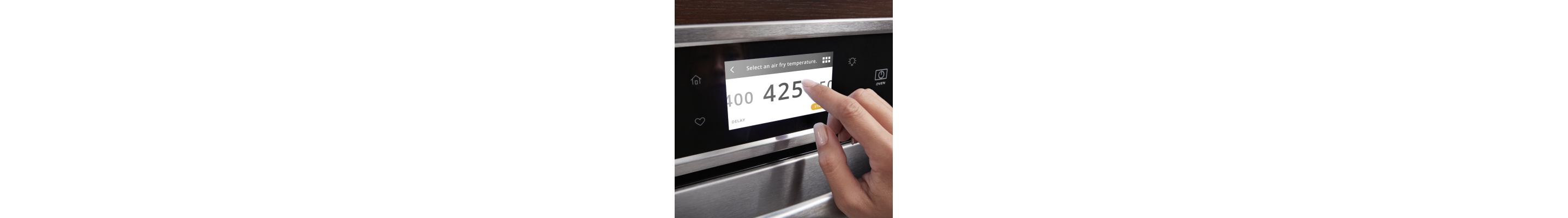 A finger setting an oven temperature