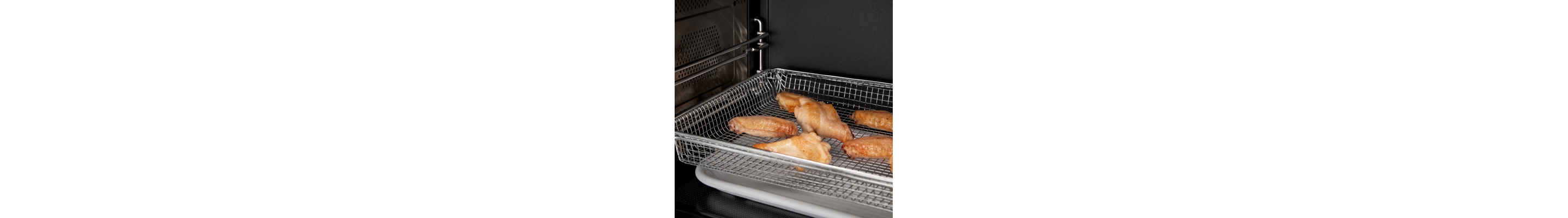 Chicken wings air frying in a basket