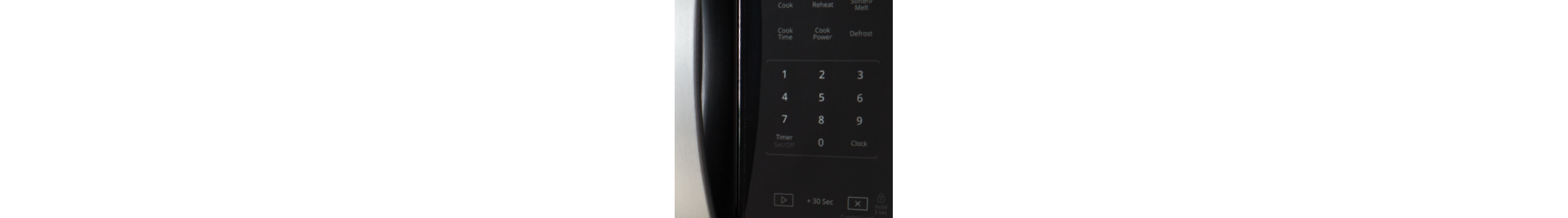 Closeup of a person using touch controls on a microwave