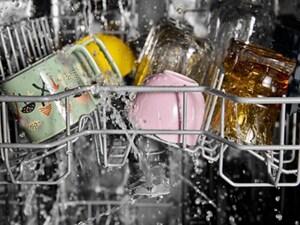 Water spraying glasses and mugs on an upper dishwasher rack