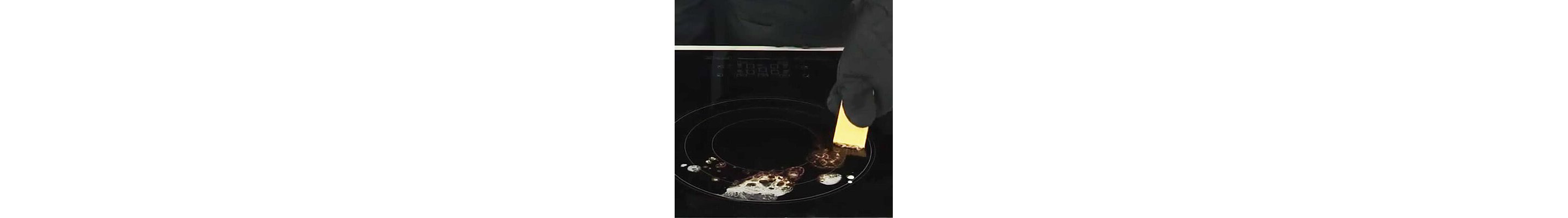 Person scraping burnt-on spills off of stovetop burner