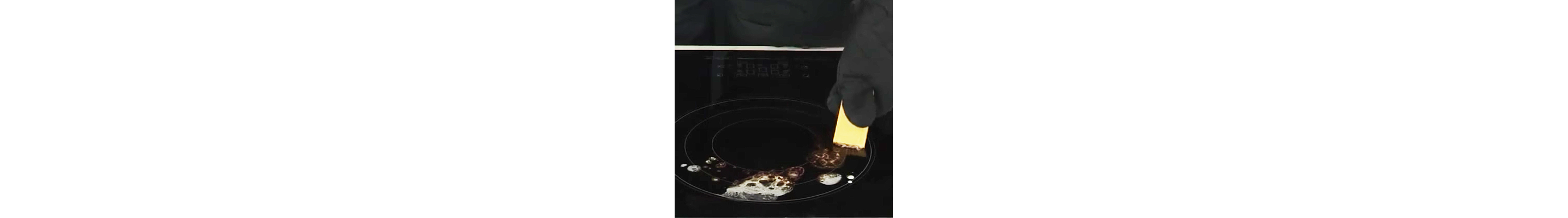 Person scraping burnt-on spills off of stovetop burner