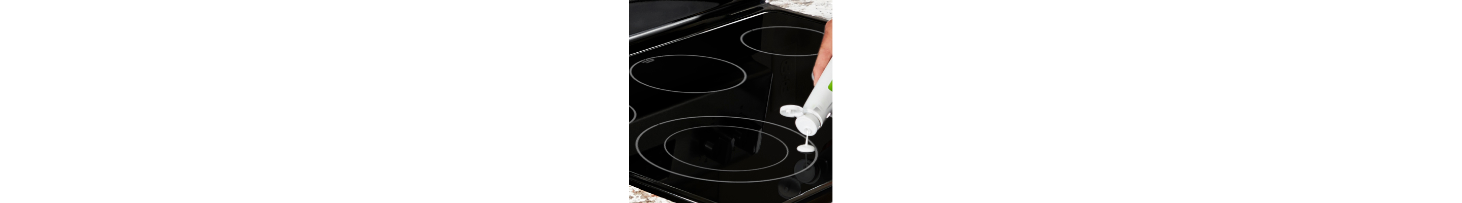 Person dripping white stovetop cleaner on electric cooktop burner