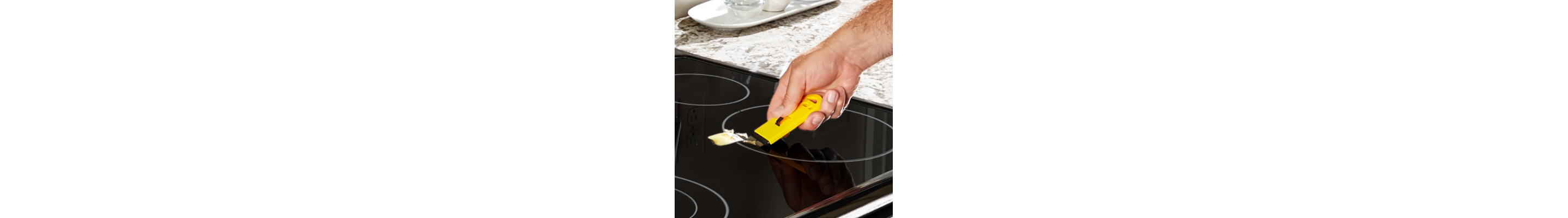 Person scraping a Whirlpool® induction cooktop