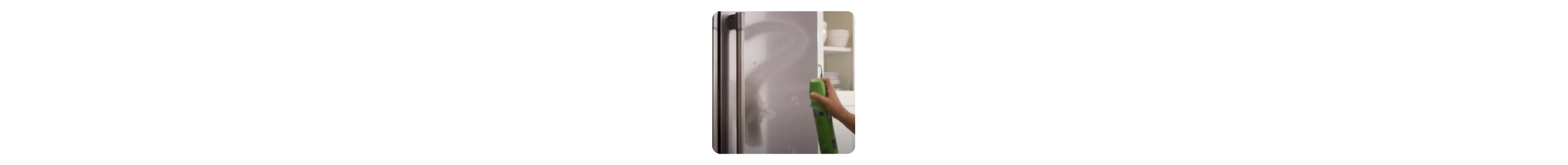 Hand spraying affresh® stainless steel cleaner onto refrigerator