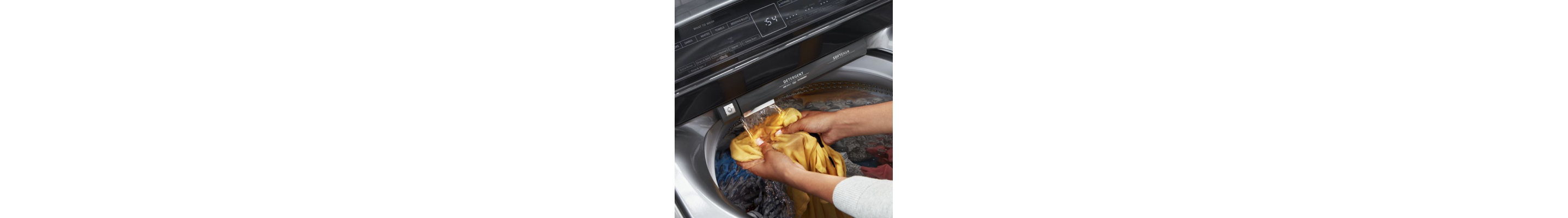 Person rinsing a garment under a built-in water faucet in a Whirlpool® Washer