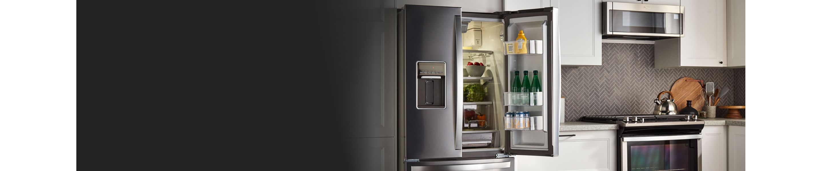 An open French Door refrigerator in a kitchen with white cabinets