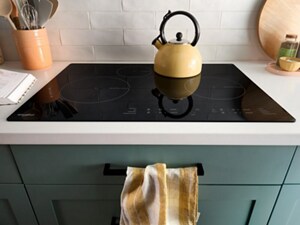 An induction cooktop from Whirlpool brand with a tea kettle on it