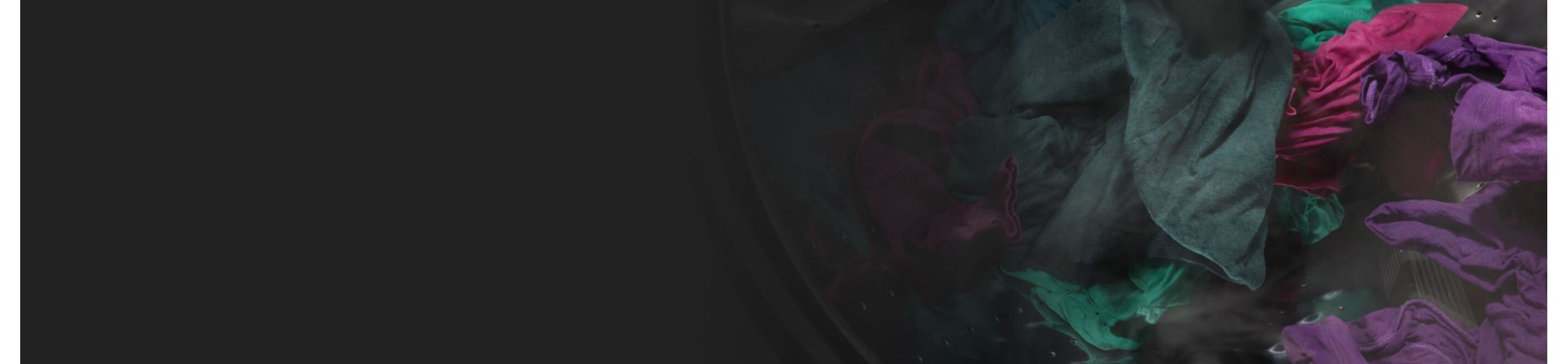 Dark purple and green clothes spinning in a washer