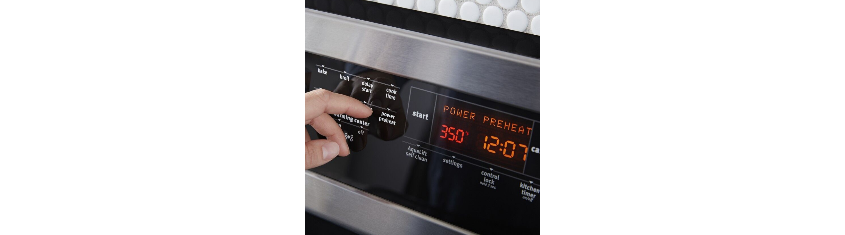 Hand making a preheat selection on the oven