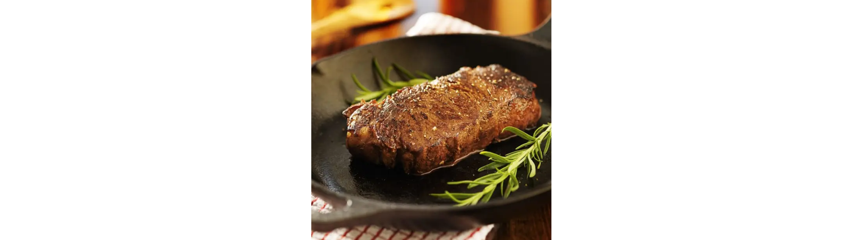 Pan seared steak in a cast iron skillet with garnish
