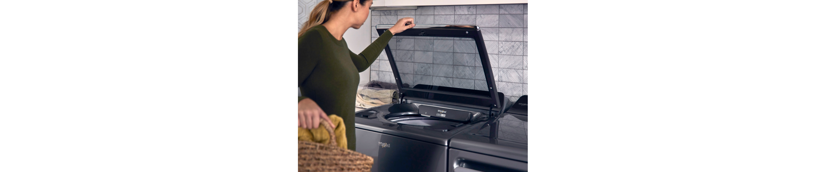 A woman opening a top load washer