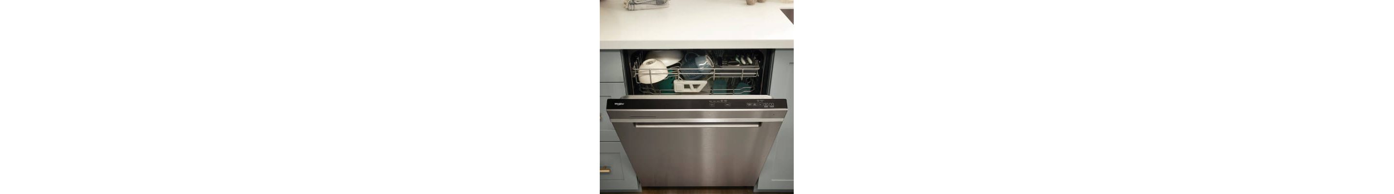 A partially opened Whirlpool® dishwasher with dishes inside