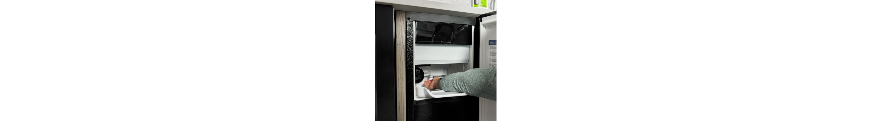 Person removing ice from an icemaker