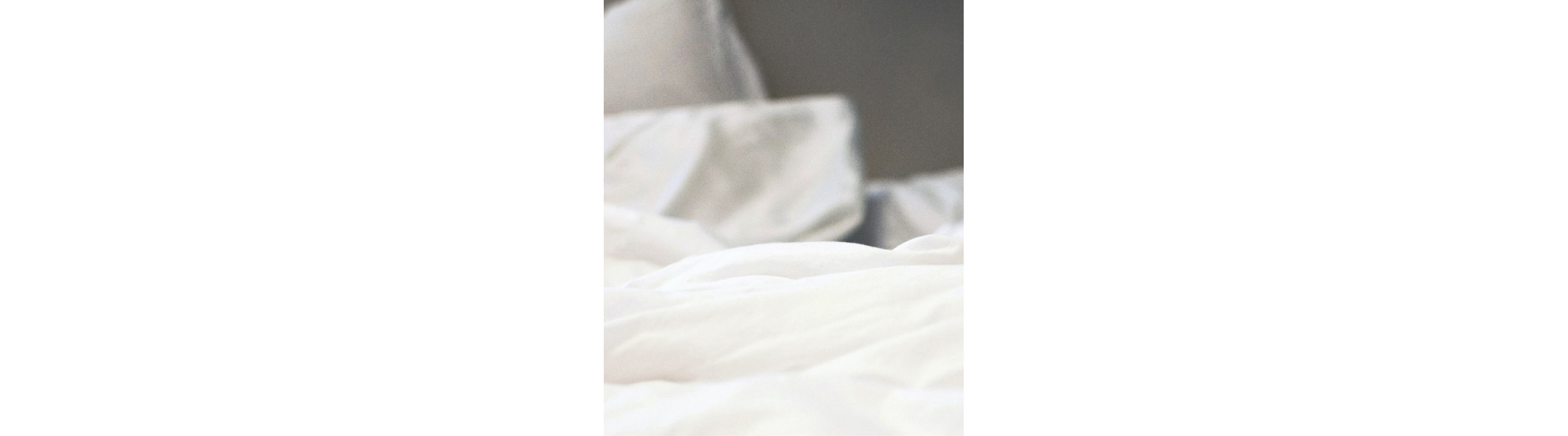 A closeup of a white comforter