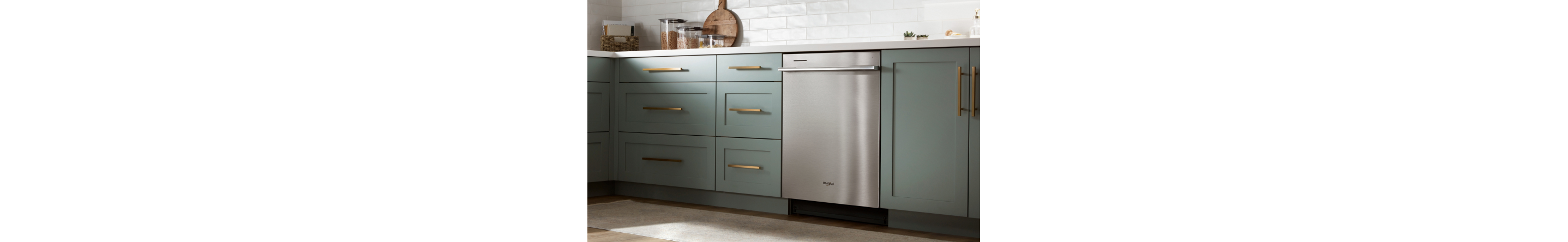 Stainless steel dishwasher in green kitchen 