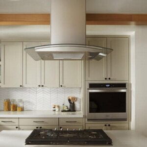 A canopy hood over a kitchen island with a cooktop