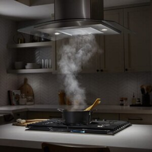Steam from a cooktop moving up into a range hood above