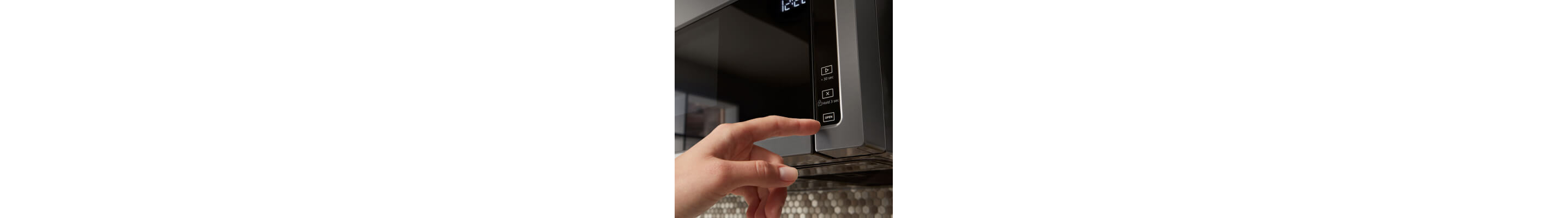 Person selecting a cook option on a Whirlpool® over-the-range microwave